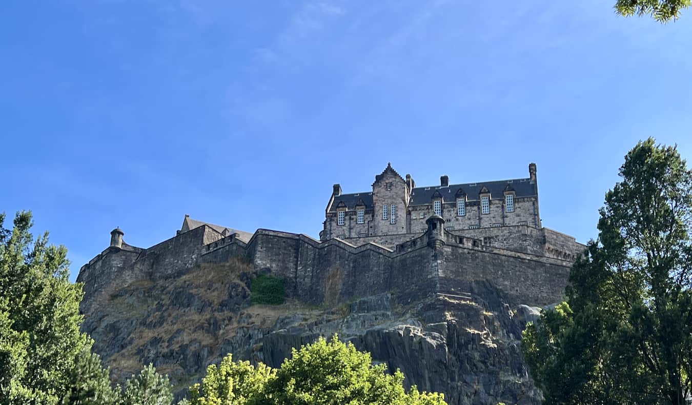 A historic old fountain near the towering Castle in Edinburgh, Scotland on a sunny day